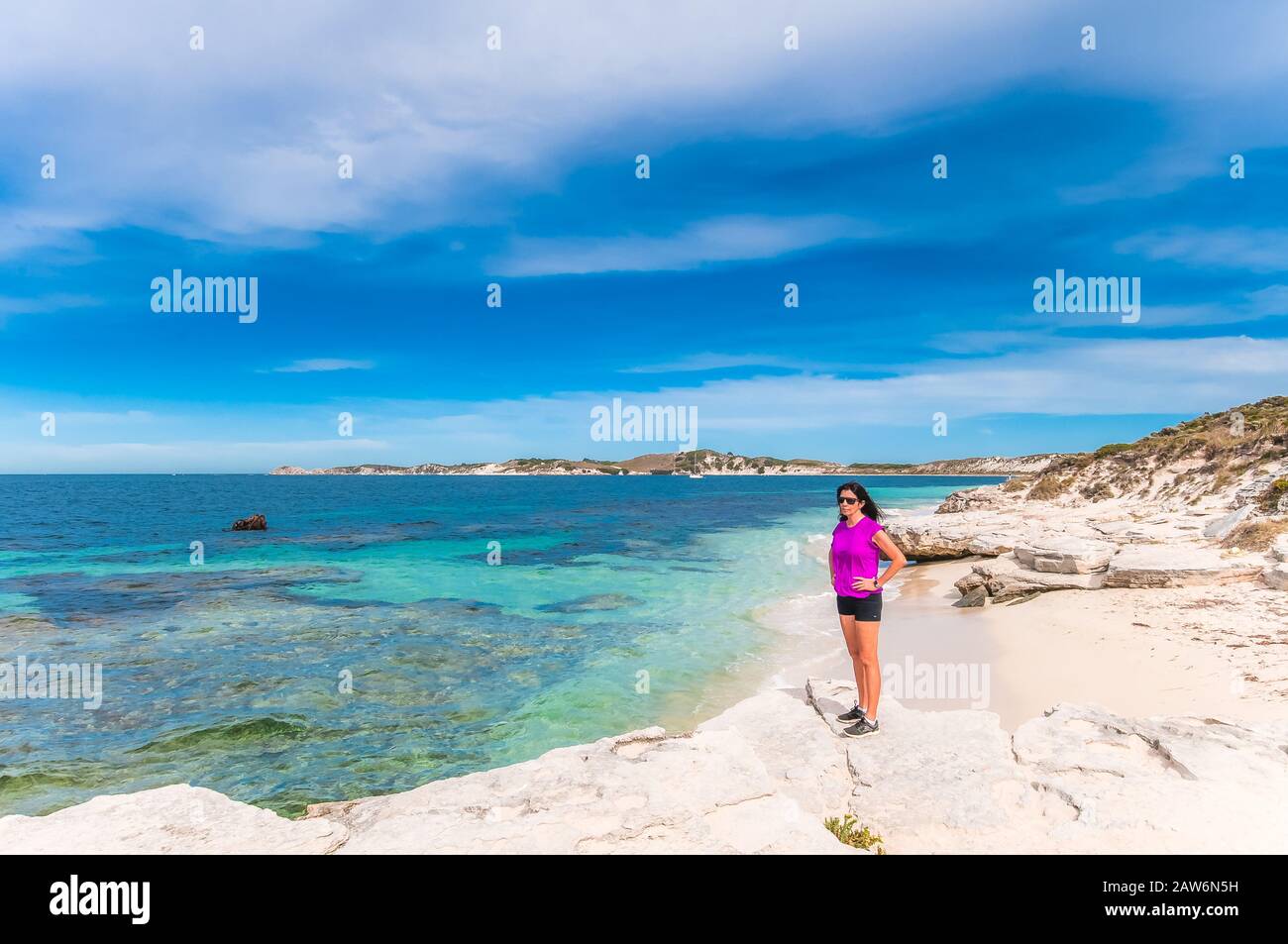 Una femmina turistica prende una pausa dal suo tour in bicicletta di rottnest Islan per ammirare le acque turchesi e la splendida spiaggia in una baia isolata. Foto Stock