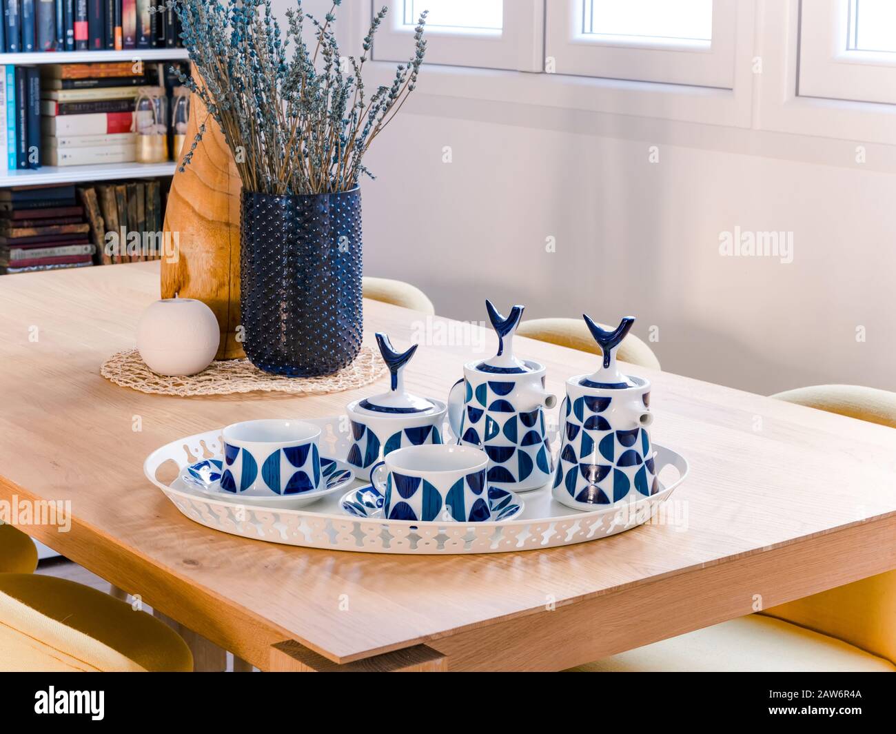Teapot in ceramica retrò e tazze su un tavolo in legno in un accogliente e luminoso soggiorno con stile naturale Foto Stock Teapot in ceramica retrò e tazze su un tavolo in legno in un accogliente e luminoso soggiorno con stile naturale Foto Stock