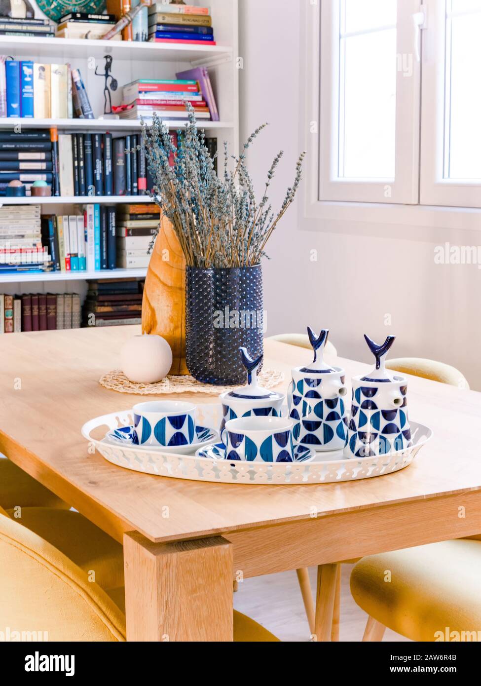Teapot in ceramica retrò e tazze su un tavolo in legno in un accogliente e luminoso soggiorno con stile naturale Foto Stock Teapot in ceramica retrò e tazze su un tavolo in legno in un accogliente e luminoso soggiorno con stile naturale Foto Stock