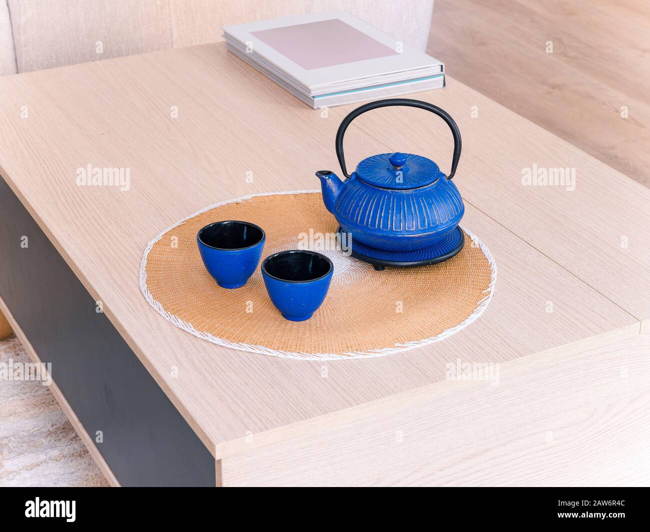 Teiera e tazze in ceramica cinese su un tavolo in legno in un accogliente e luminoso soggiorno in stile naturale Foto Stock
