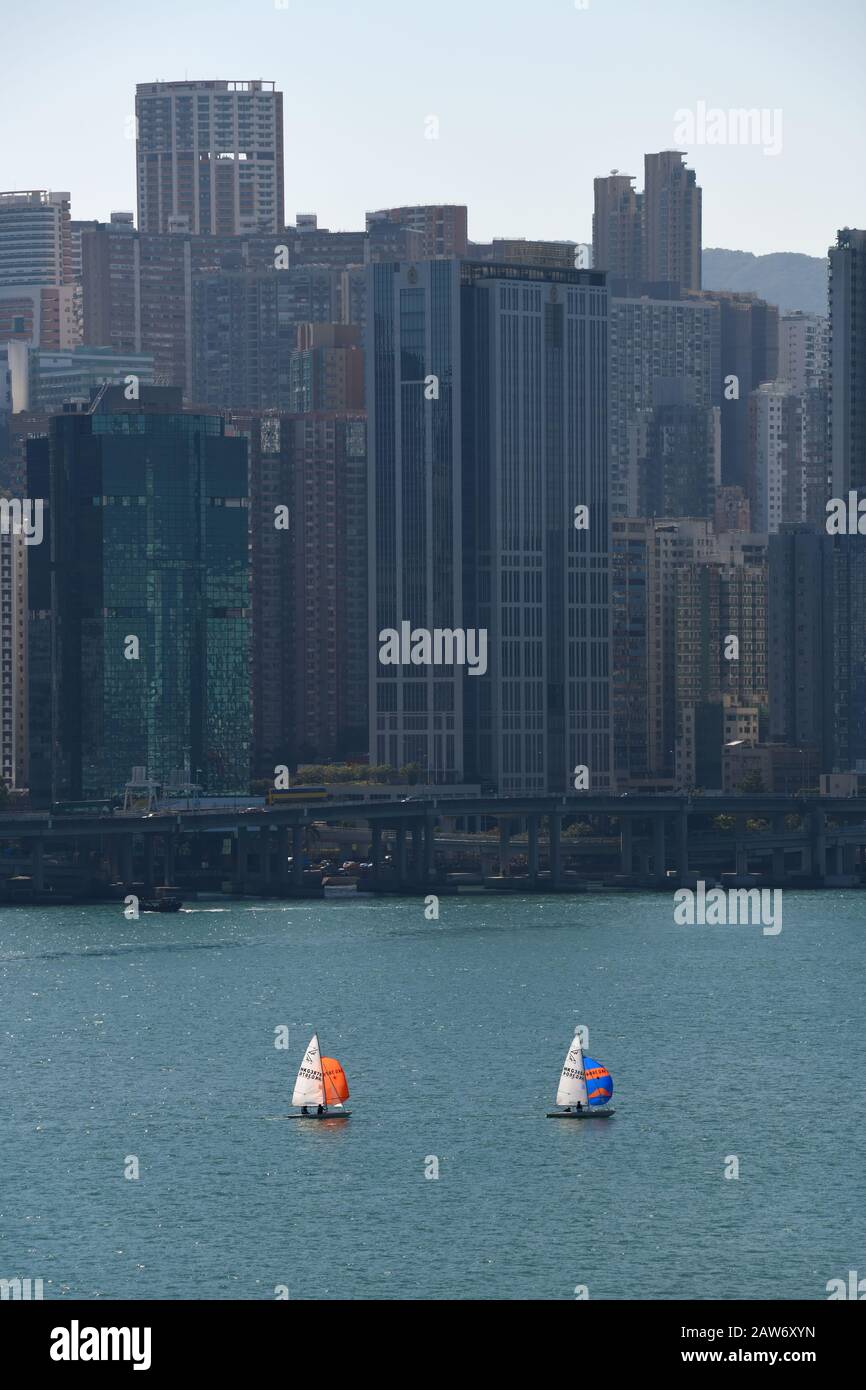 I piccoli yacht sono svegli dagli alti edifici nella Kowloon Bay, Hong Kong, Cina Foto Stock