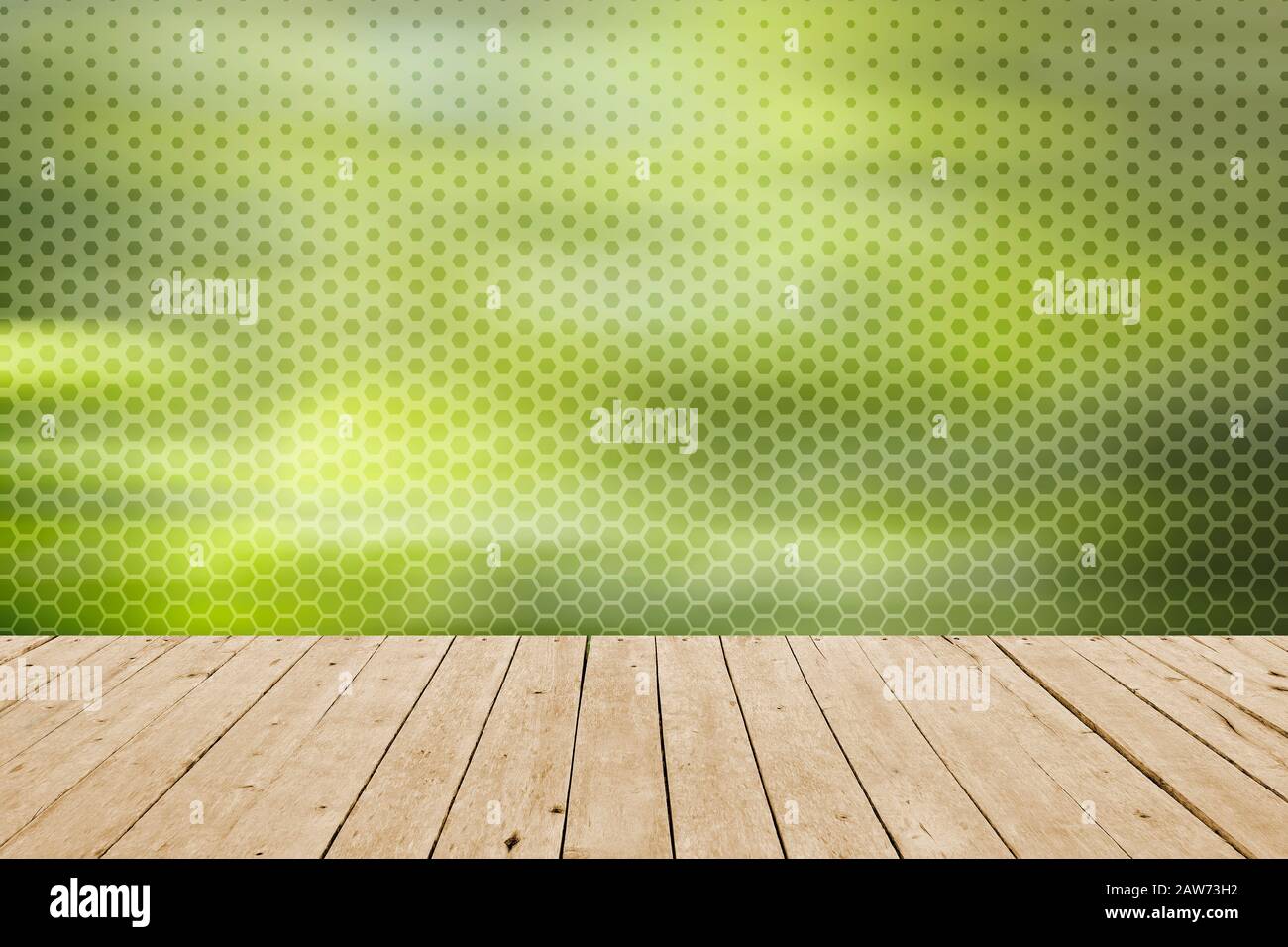 Sfondo con tavolo in legno e carta da parati verde a scatola esagonale Foto Stock