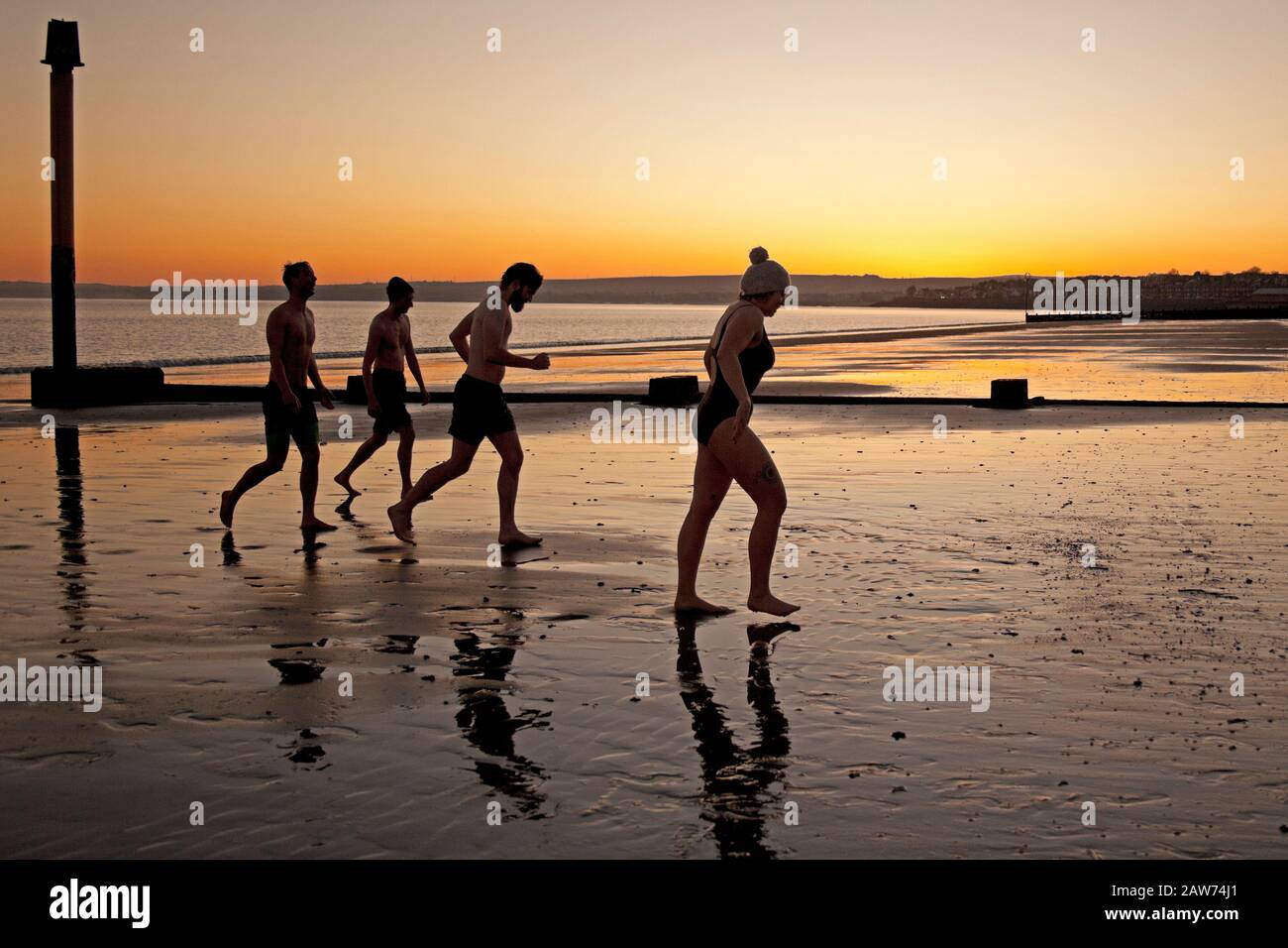 Portobello Beach, Edimburgo, Scozia, Regno Unito. 7th feb.2020. Temperatura di meno 2 gradi, ma questi giovani nuotatori selvaggi Joe, Rachel, Andrew e Joe che si chiamano i Nuotatori selvatici New Story hanno goduto il tuffo di rinforzo nel Firth of Forth all'alba. Foto Stock