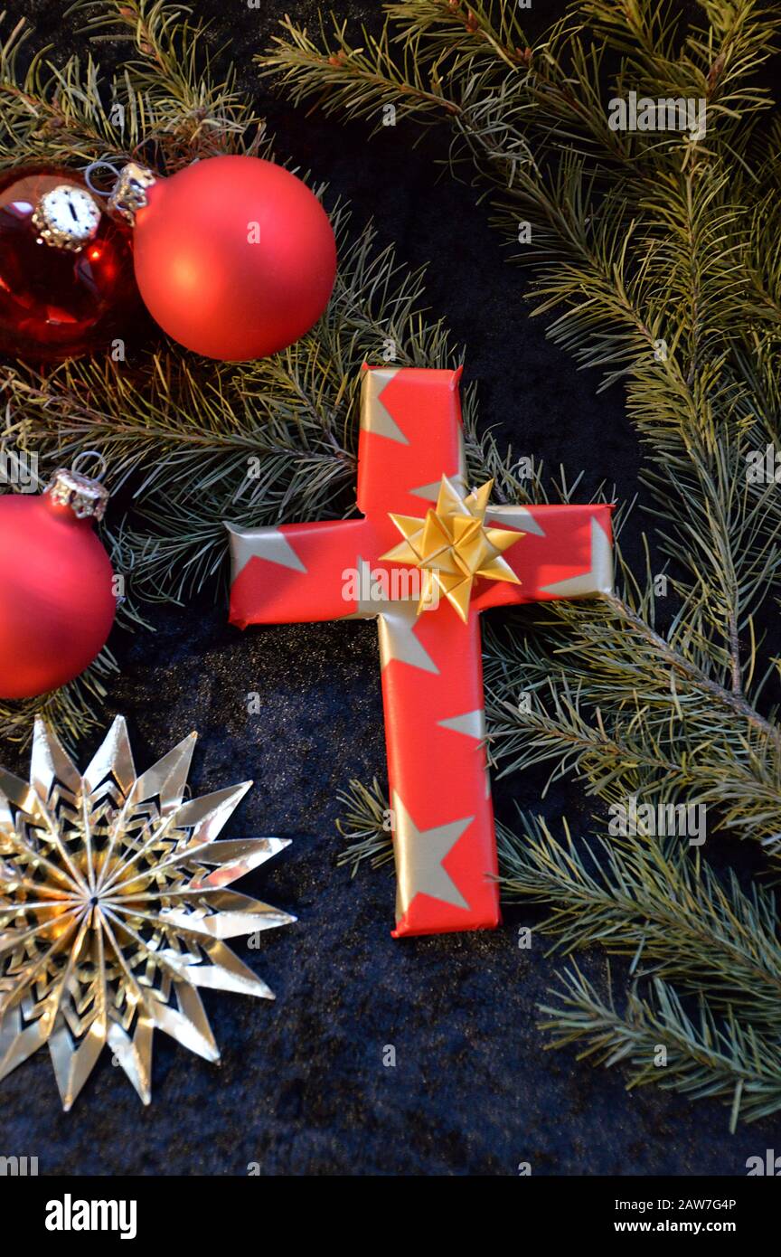 Croce avvolta in carta come un regalo al giorno di Natale come un simbolo,  che Gesù non è nato per vivere sulla terra come un re ricco, ma per morire  per i