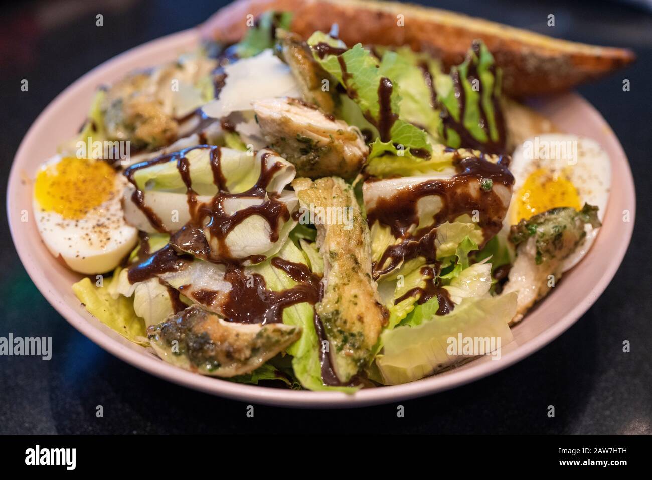 Insalata caesar di pollo deliziosa. Insalata Di Pollo. Caesar Salad con pollo alla griglia, uova bollite a fette e verdure fresche su piatto. Foto Stock