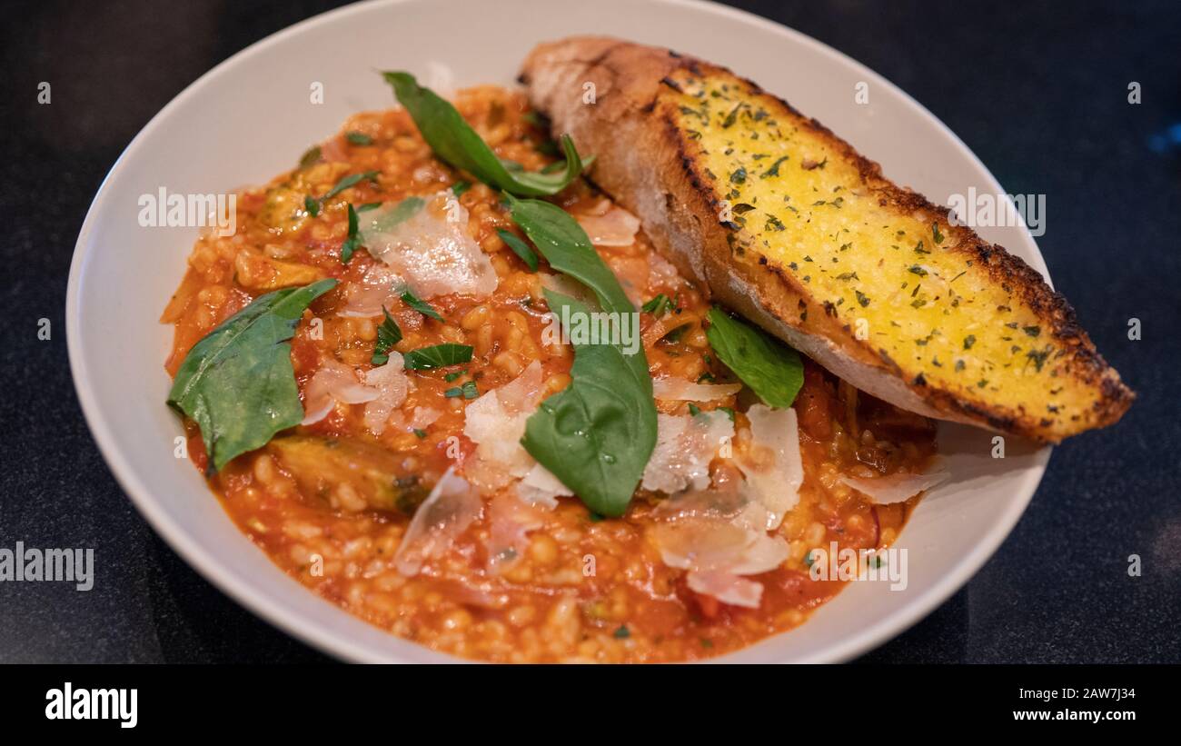 Primo piano di riso fritto con salsa di pomodoro. Riso con verdure e un pezzo di pane su piastra. Foto Stock