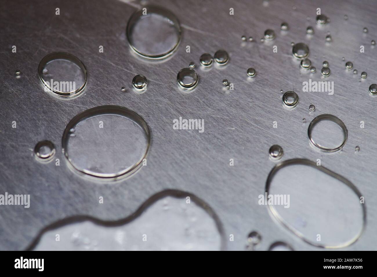 Cerchi di gocce d'acqua su sfondo metallico vista ravvicinata Foto Stock