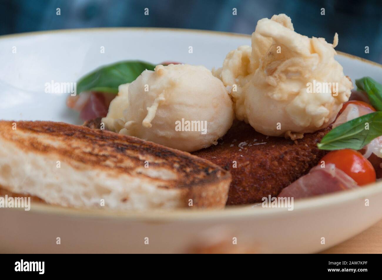 Chiudete la colazione con uova in camicia su toast alla pasta con pomodori ciliegini e verdure. Il cibo di fondo Foto Stock