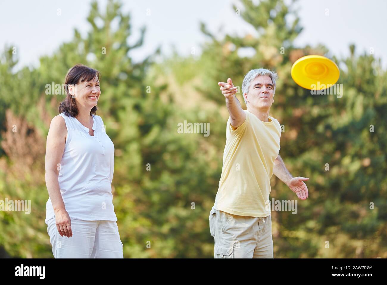 Felice coppia di anziani giocando frisbee in estate nel parco Foto Stock