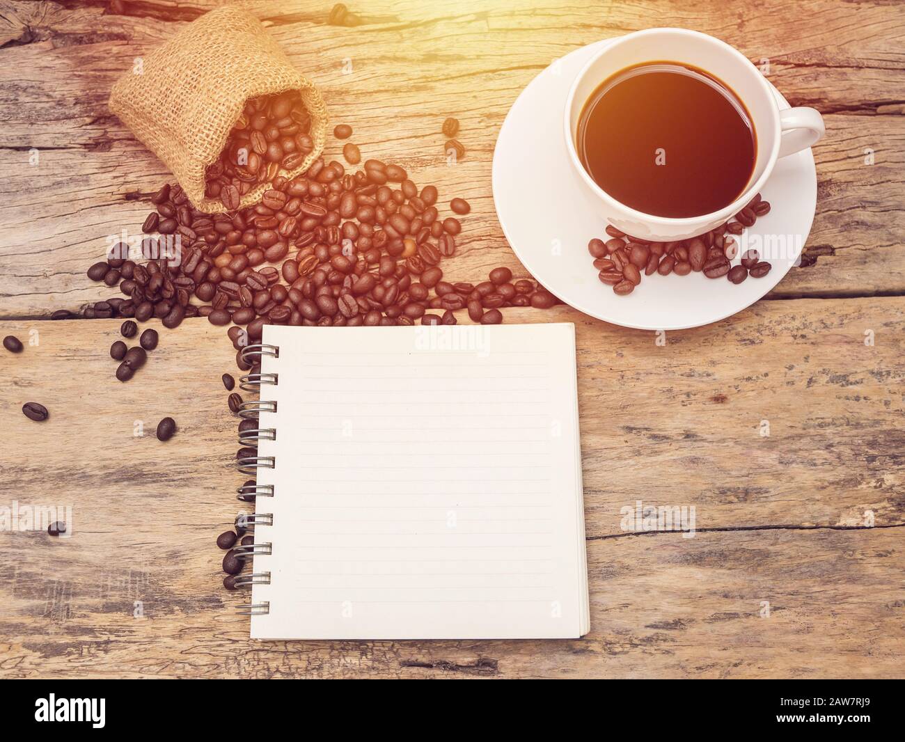 caffè caldo con chicco di caffè e taccuino su tavolo di legno. menu di fondo del caffè per caffetteria o caffetteria Foto Stock