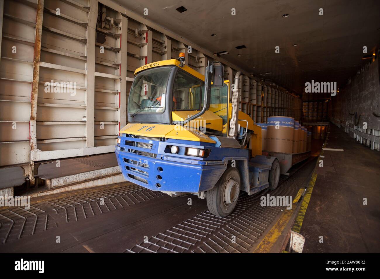 I rotoli di carta vengono scaricati dalla nave al terminal portuale Foto Stock