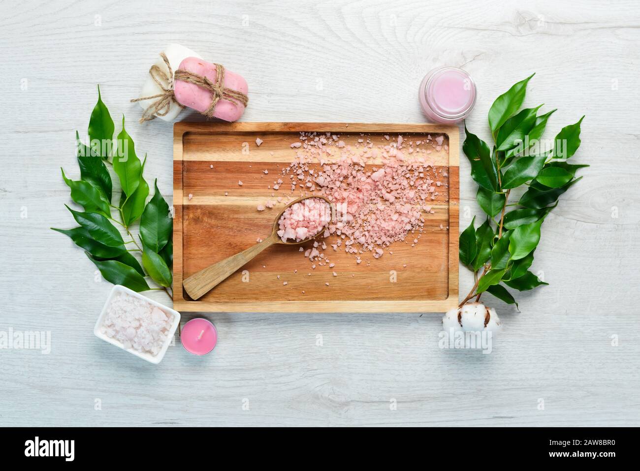 Cosmetici a base di rose. Sapone e sale marino su una tavola bianca. Vista dall'alto. Spazio libero per il testo. Foto Stock