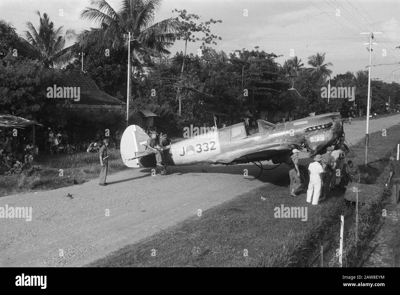 Atterraggio di emergenza di un Curtiss P40 vicino a solo Recentemente, un aereo da combattimento Curtiss P40 crash-atterrato alla periferia di solo. Poiché non c'era alcuna possibilità di fissare l'unità sul posto e togliere sul campo di acqua registrato era impossibile, l'aereo da parte dei militari è stato trascinato altrove per essere smantellato. Trascinare l'aeromobile sulla strada Annotazione: Registrazione n. .: J332 Data: 13 aprile 1949 Ubicazione: Bondowoso, Indonesia, Java, Indie Orientali olandesi Foto Stock