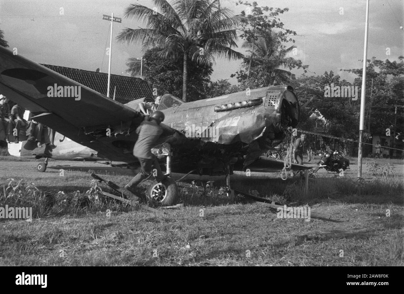 Atterraggio di emergenza di un Curtiss P40 vicino a solo Recentemente, un aereo da combattimento Curtiss P40 crash-atterrato alla periferia di solo. Dato che non c'era la possibilità di fissare l'unità sul posto e decollare sul campo d'acqua era impossibile, l'aereo da parte dei militari è stato trascinato altrove per smantellare Data: 13 aprile 1949 luogo: Bondowoso, Indonesia, Java, India olandese Foto Stock