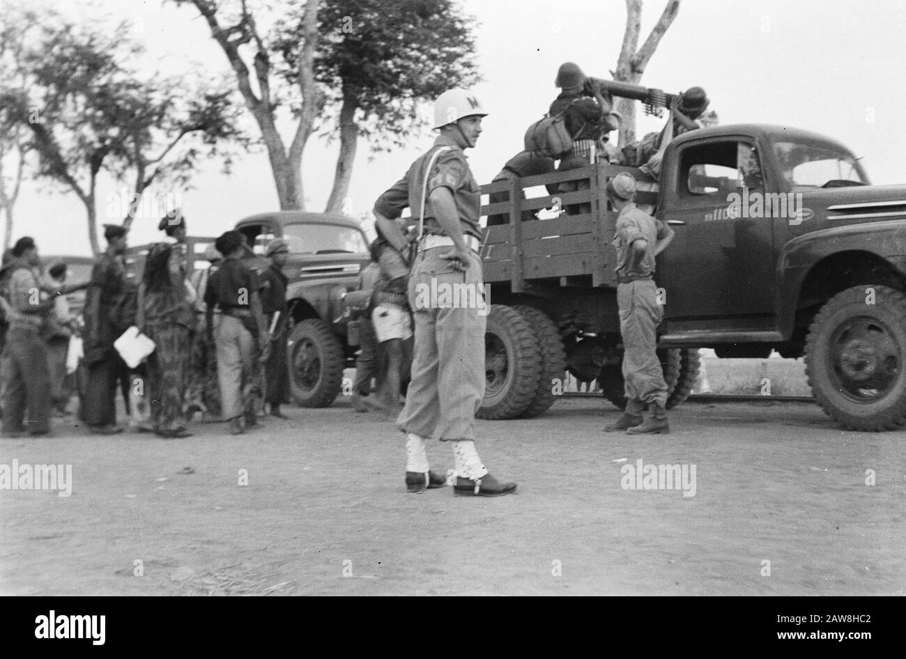 Area di trasferimento Ponorogo Military Police Watches as drietonners be loaded by TNI Soldiers, including a heavy machine Date: October 23, 1949 Location: Indonesia, Java , Dutch East Indies Foto Stock