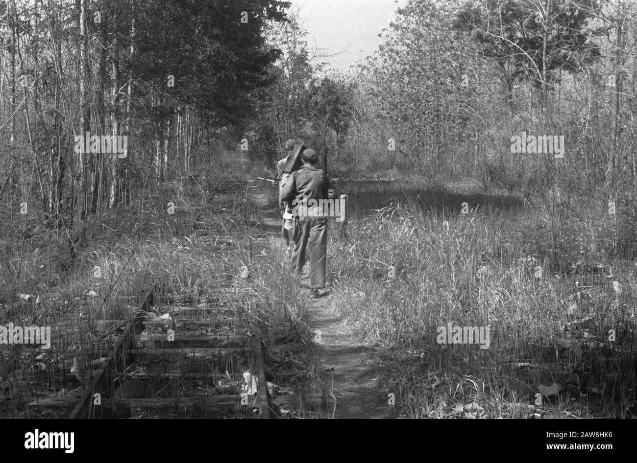 I soldati camminano lungo una ferrovia disusata. Tra loro probabilmente è l'uomo di immagine laterale. 1305 Data: Ottobre 1948 Luogo: Indonesia Indie Orientali Olandesi Foto Stock