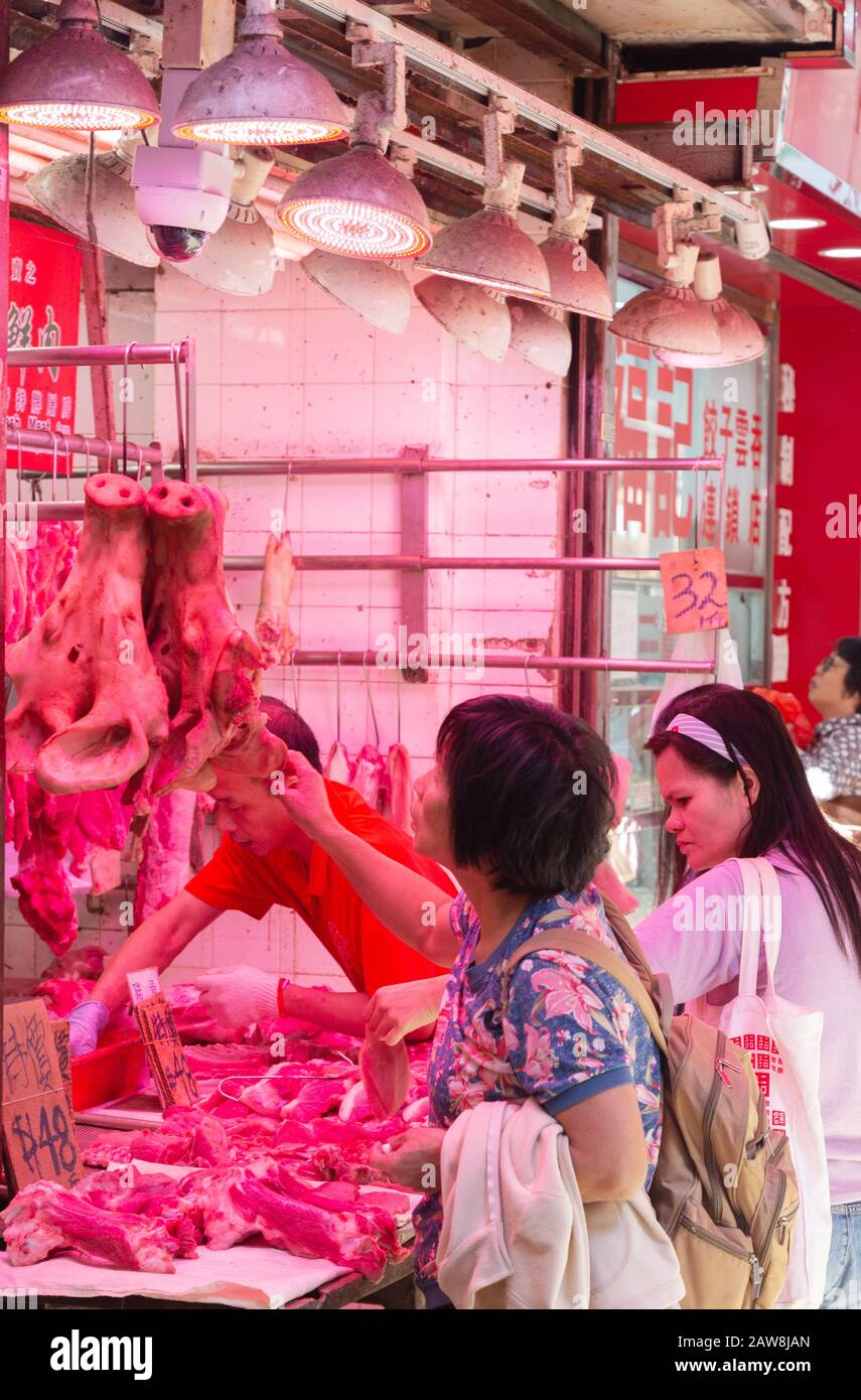 Cibo di Hong Kong; shopping femminile per il cibo in un negozio di macellai, mercato Di Wan Chai, Hong Kong Island Hong Kong Asia Foto Stock