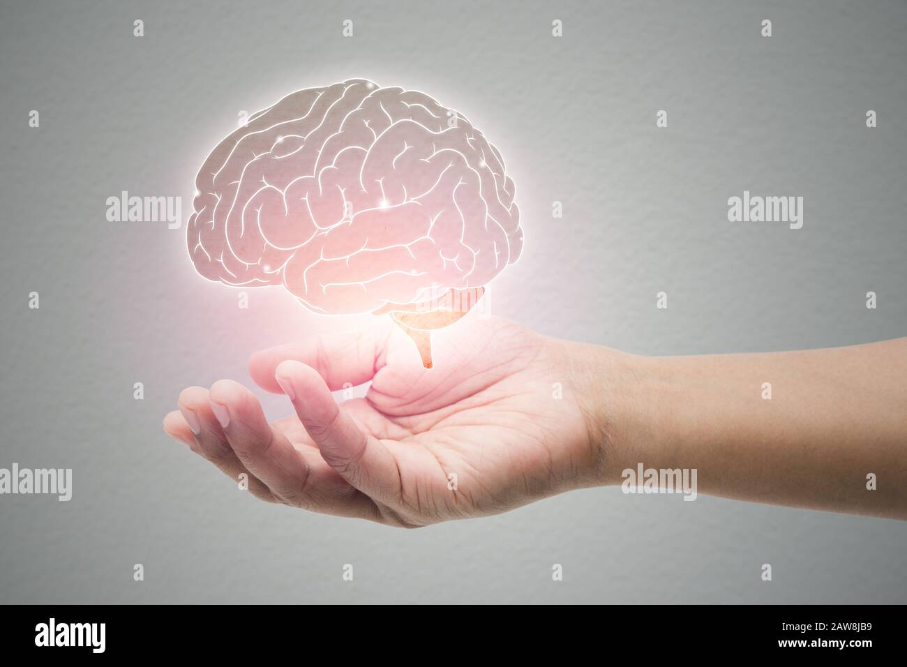 L'uomo che tiene l'illustrazione del cervello contro lo sfondo grigio della parete. Concetto con protezione e cura mentale della salute, morbo di Alzheimer Foto Stock