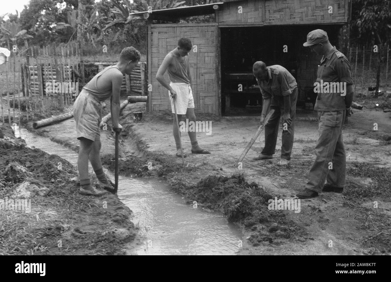 Foto da articoli artiglieria fa storia e Alloggio nella giungla nella rivista Wapenbroeders Marihat. Campo Militare. [Scavare canali di drenaggio e / o fogna?] Annotazione: Marihat? Buntu Turunan? (Simalungun Nord Sumatra). Il reggimento è di 5-11 R.I. Date: 14 Novembre 1948 Location: Indonesia Dutch East Indies Foto Stock