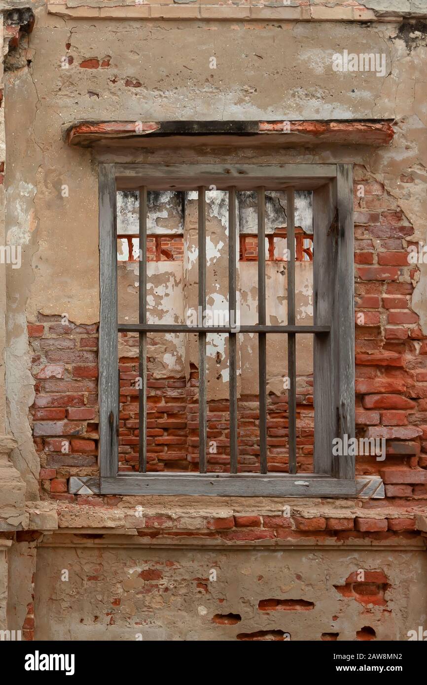 muro in cemento con mattoni rossi esposti e cella in legno jail come finestra. Trama astratta sfondo con spazio di copia, Esposto, Recintato o Clo Foto Stock