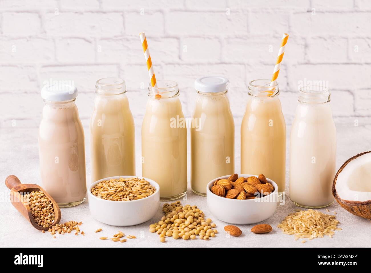 A bottiglie di latte alternativi e gli ingredienti per cucinare. Foto Stock