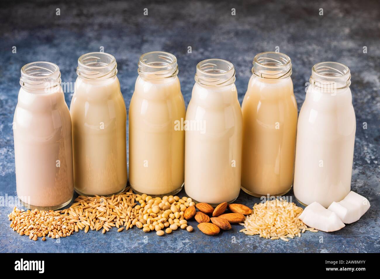 A bottiglie di latte alternativi e gli ingredienti per cucinare. Foto Stock