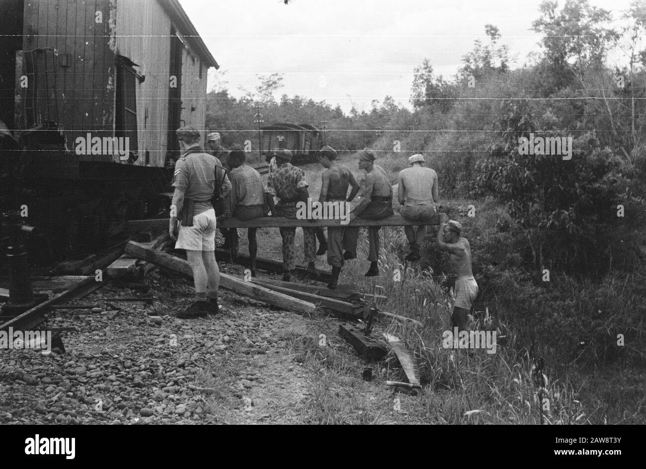 Repubblica Palembang (treno deragliato, paziente indonesiano, cura ferita) Palembang: Tra Muara Enim e Lahat è stato il TNI ha reso la ferrovia disabili con il risultato che ha gestito un treno passeggeri dalle rotaie. [Unendosi alle forze e sedendosi in un bar provando gli ingegneri olandesi un carro ferroviario ancora in pista] Data: Luglio 1947 luogo: Indonesia, Indie orientali olandesi, Sumatra Foto Stock