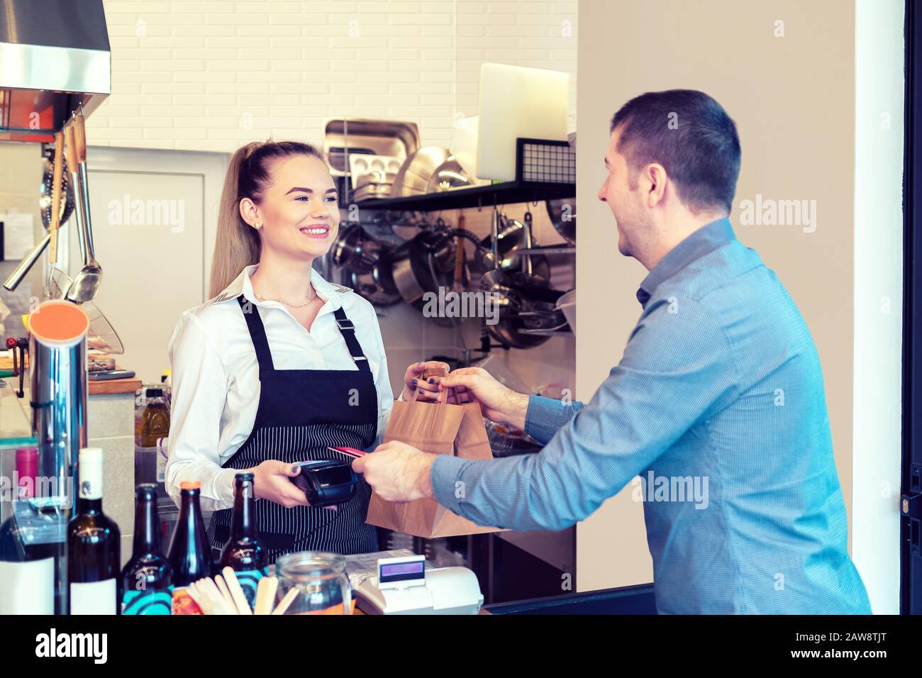 Cliente che paga per andare ordine con carta di credito in piccolo ristorante Foto Stock