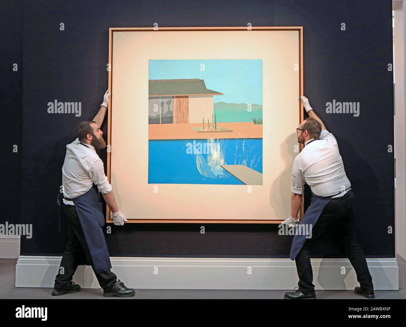 Due dipendenti della Sotheby's Gallery regolano la pittura di David Hockney, The Slash, durante una chiamata fotografica per la vendita di arte contemporanea della casa d'asta nel centro di Londra. Foto Stock
