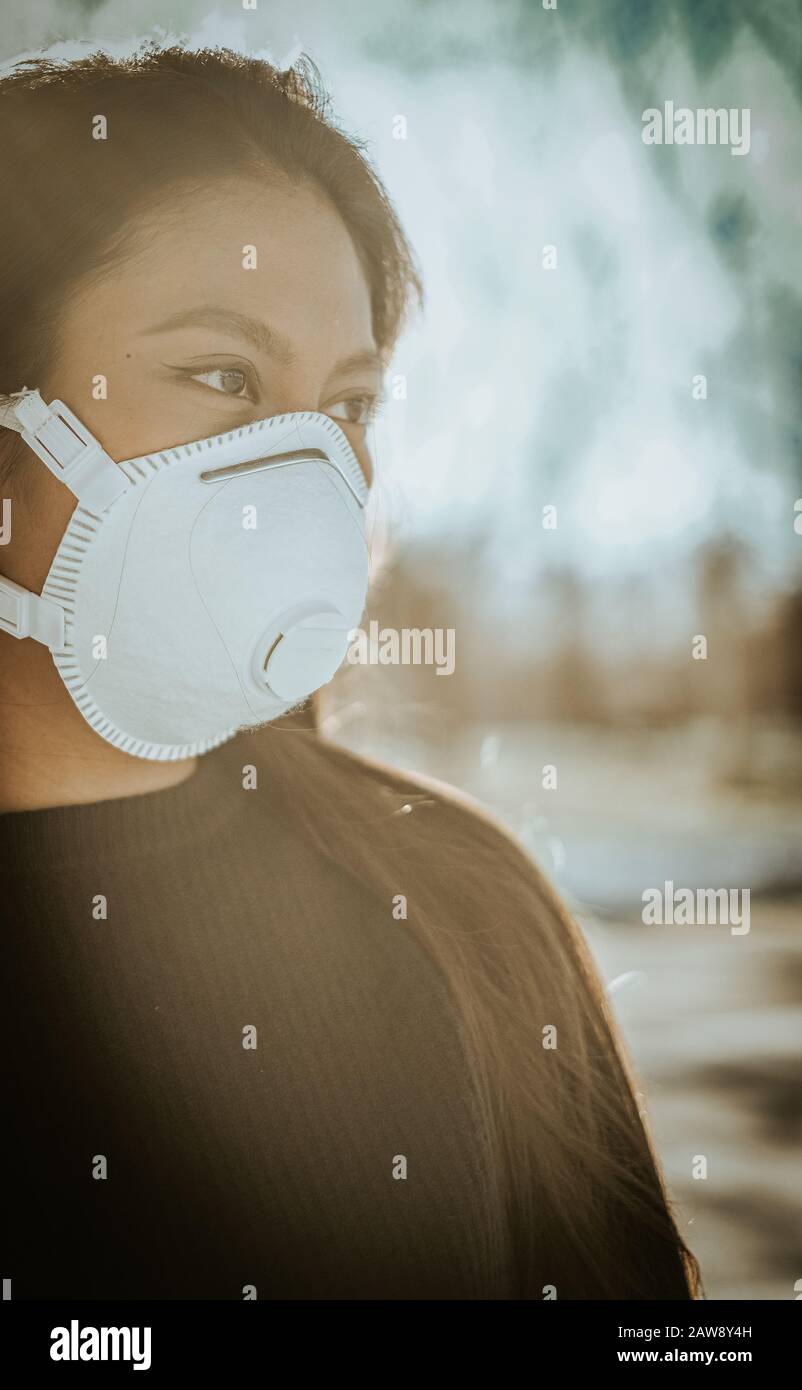 Una donna cinese con una maschera respiratoria per evitare il pericolo di infezione Foto Stock