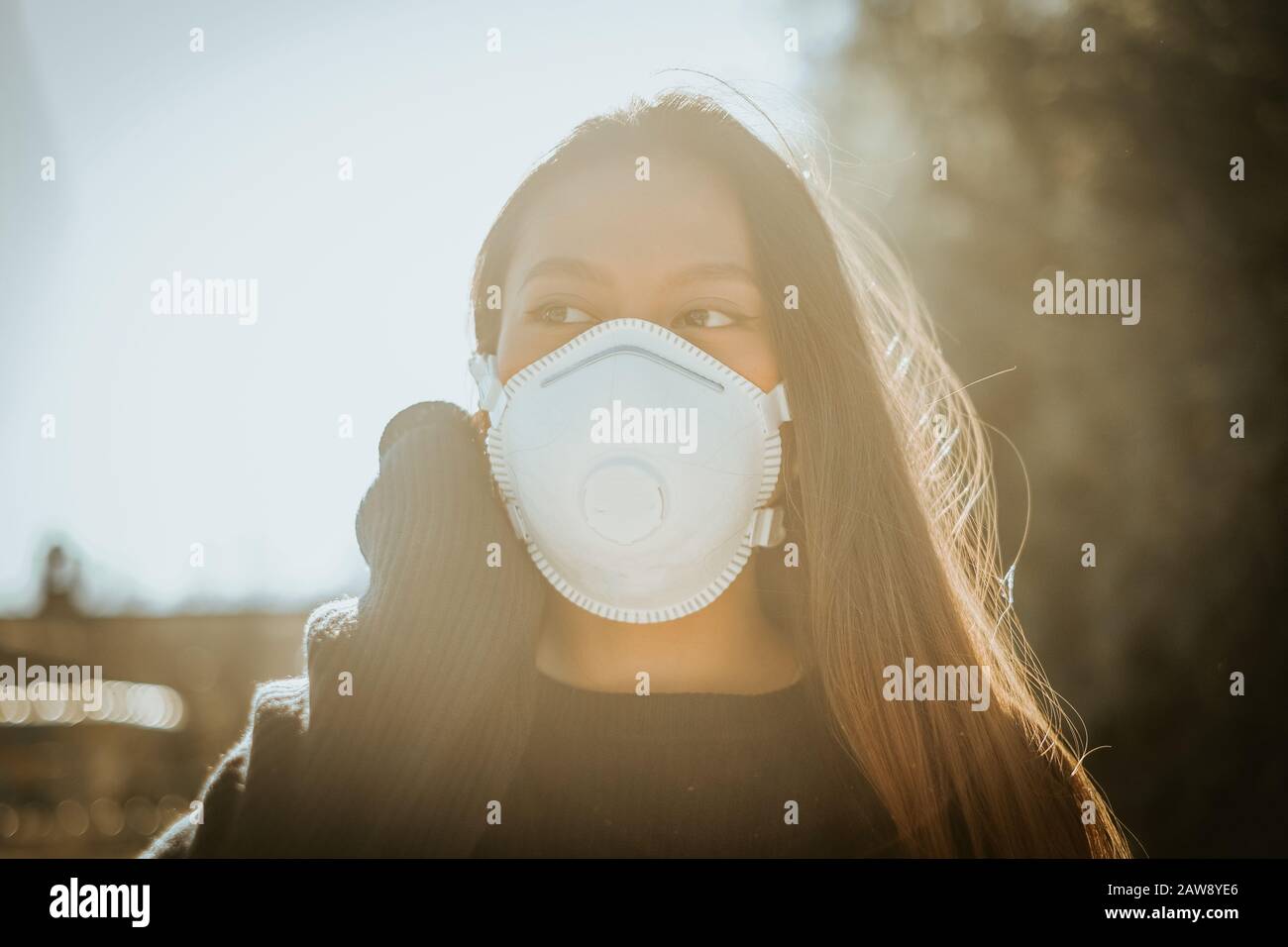 Una donna cinese con una maschera respiratoria per evitare il pericolo di infezione Foto Stock