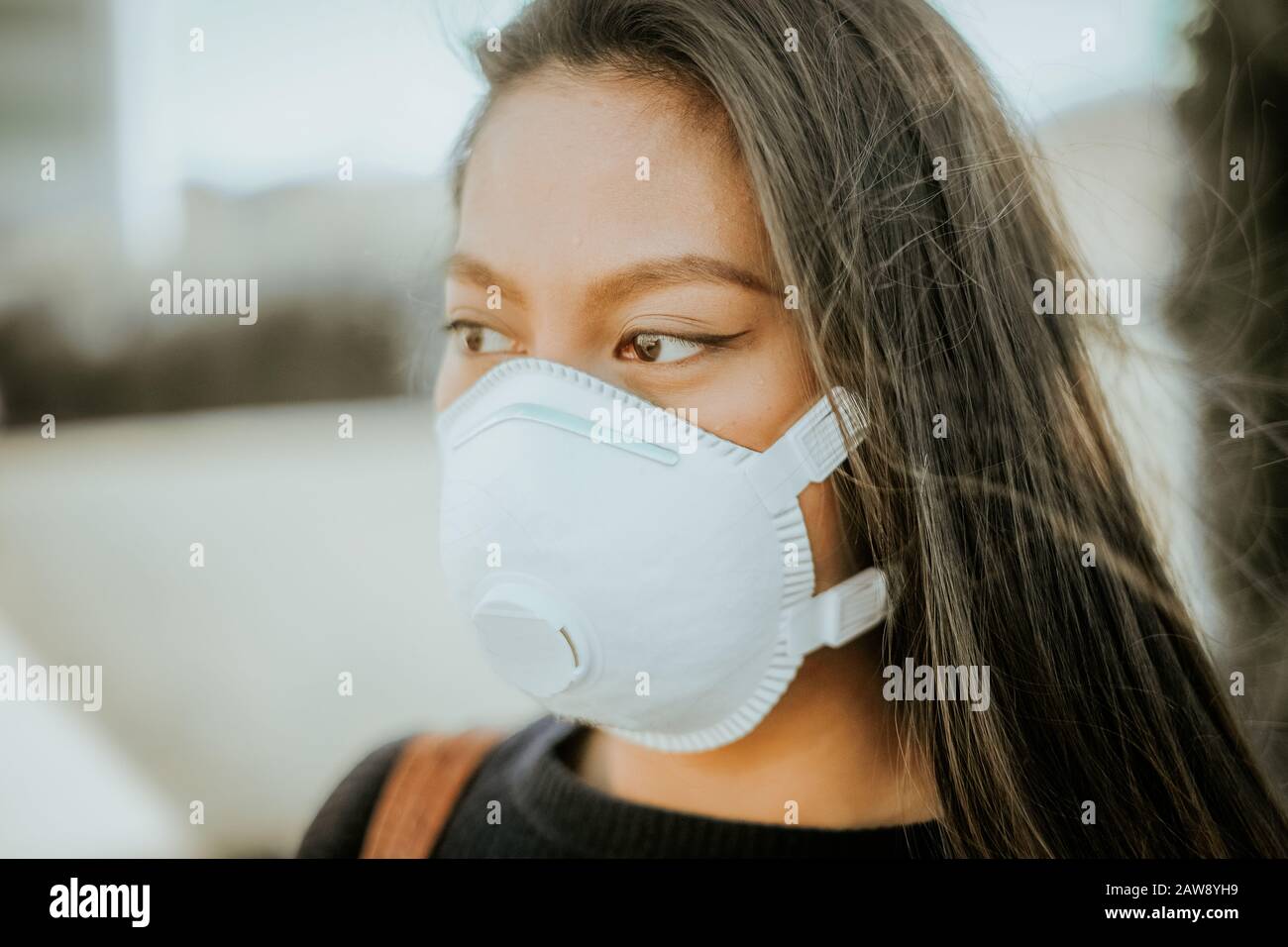 Una donna cinese con una maschera respiratoria per evitare il pericolo di infezione Foto Stock