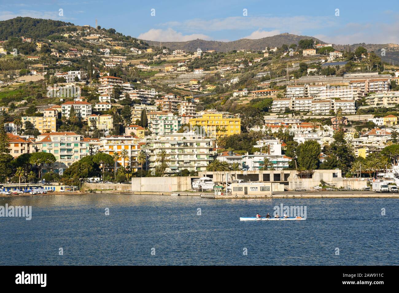 Vista panoramica dal mare della città costiera della Riviera dei Fiori con gente che canoa in una giornata di sole, Sanremo, Liguria, Italia Foto Stock