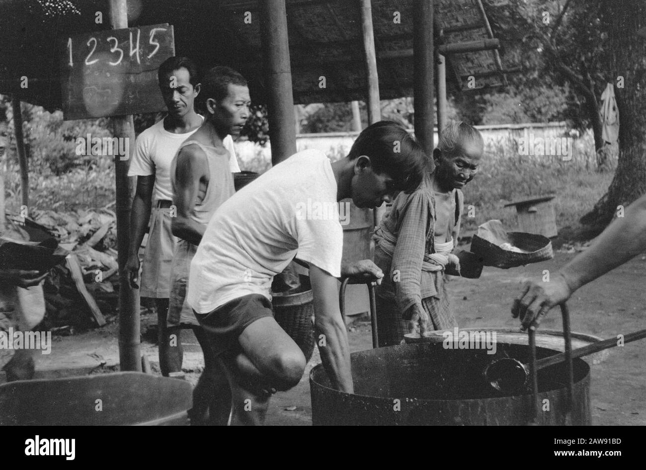 Membri del lavoro Croce Rossa e Dipartimento degli Affari sociali a Blitar Dopo l'occupazione di Blitar arrivò la Croce Rossa, che immediatamente fece un inizio per alleviare le difficoltà estreme. La popolazione di villaggio ragged-clad era totalmente emaciated, così fornendo il cibo che era più necessario. Data: 20 Gennaio 1949 Luogo: Blitar, Java Foto Stock