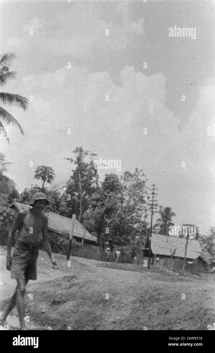 Uomo in pantaloncini e cappello a piedi in un kampong Data: 1947 posizione: Indonesia Dutch East Indies Foto Stock
