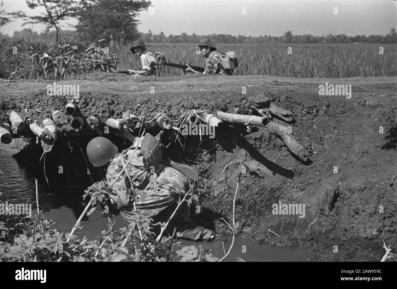 Pattuglia Gang. Il soldato olandese guarda sotto un ponte di bambù. Di fronte sono due soldati dietro la diga di un campo di riso Annotazione: Questo è lo stesso miltair della miniera di compensazione Data: 01.01.1947 posizione: Indonesia Dutch East Indies Foto Stock