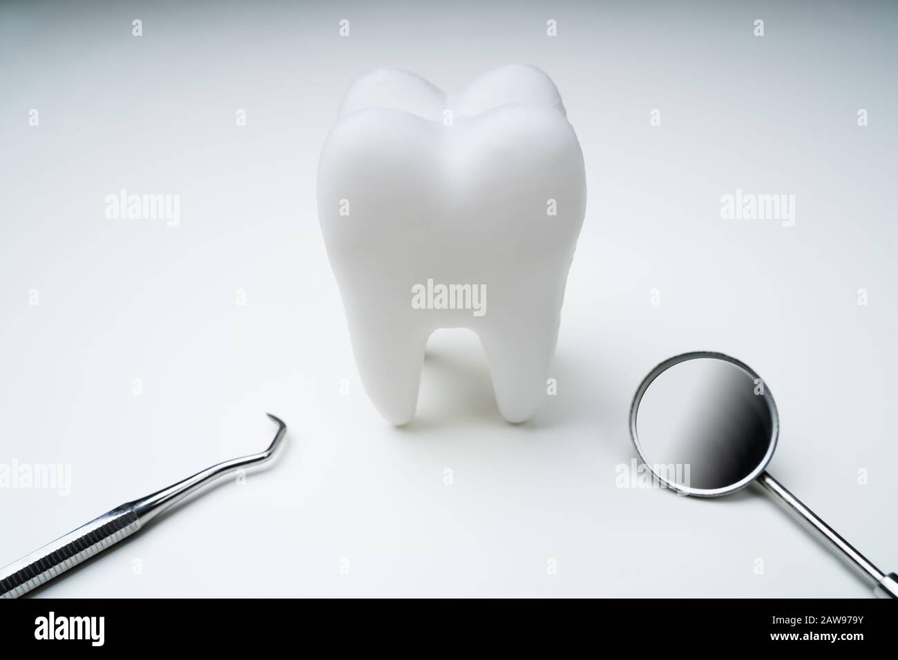 Primo Piano Del Dente Con Specchio Dentale Su Sfondo Bianco Foto Stock