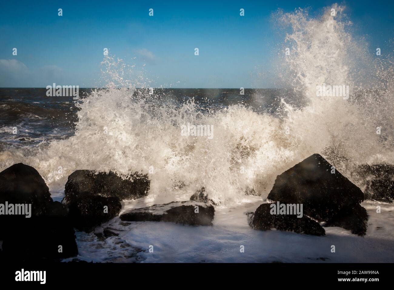 Molo all'angolo dell'Olanda, con blocchi di basalto e spruzzi e acqua schiumosa del Mare del Nord in inverno. Foto Stock