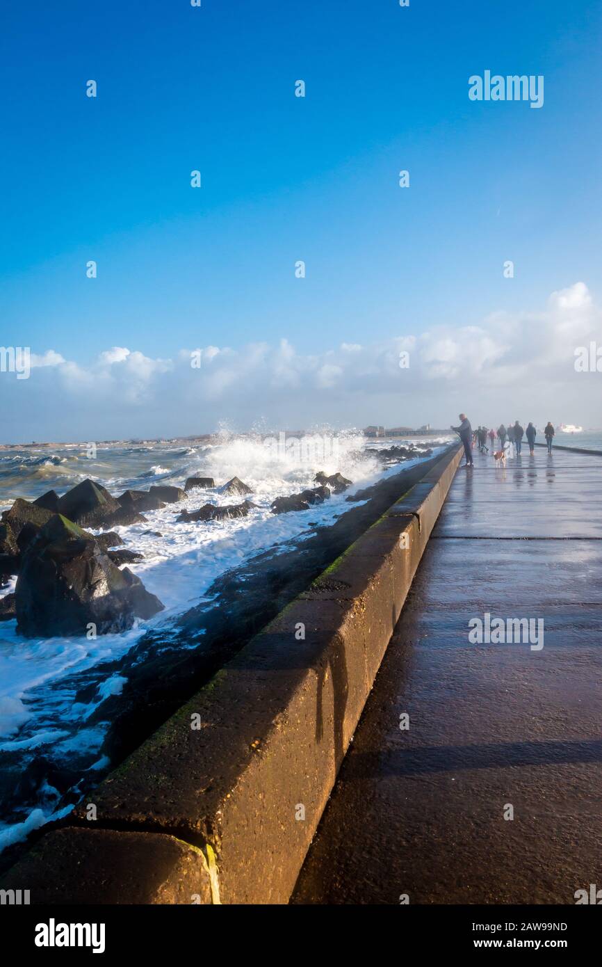 Molo all'angolo dell'Olanda, con blocchi di basalto e spruzzi e acqua schiumosa del Mare del Nord in inverno. Foto Stock