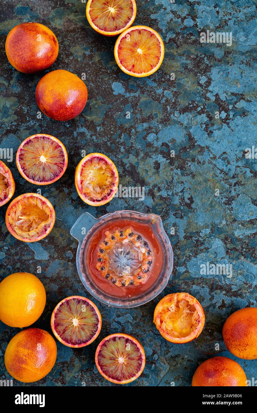 Juicing arance di anima. Succo d'arancia e arance sanguigne su ardesia Foto Stock