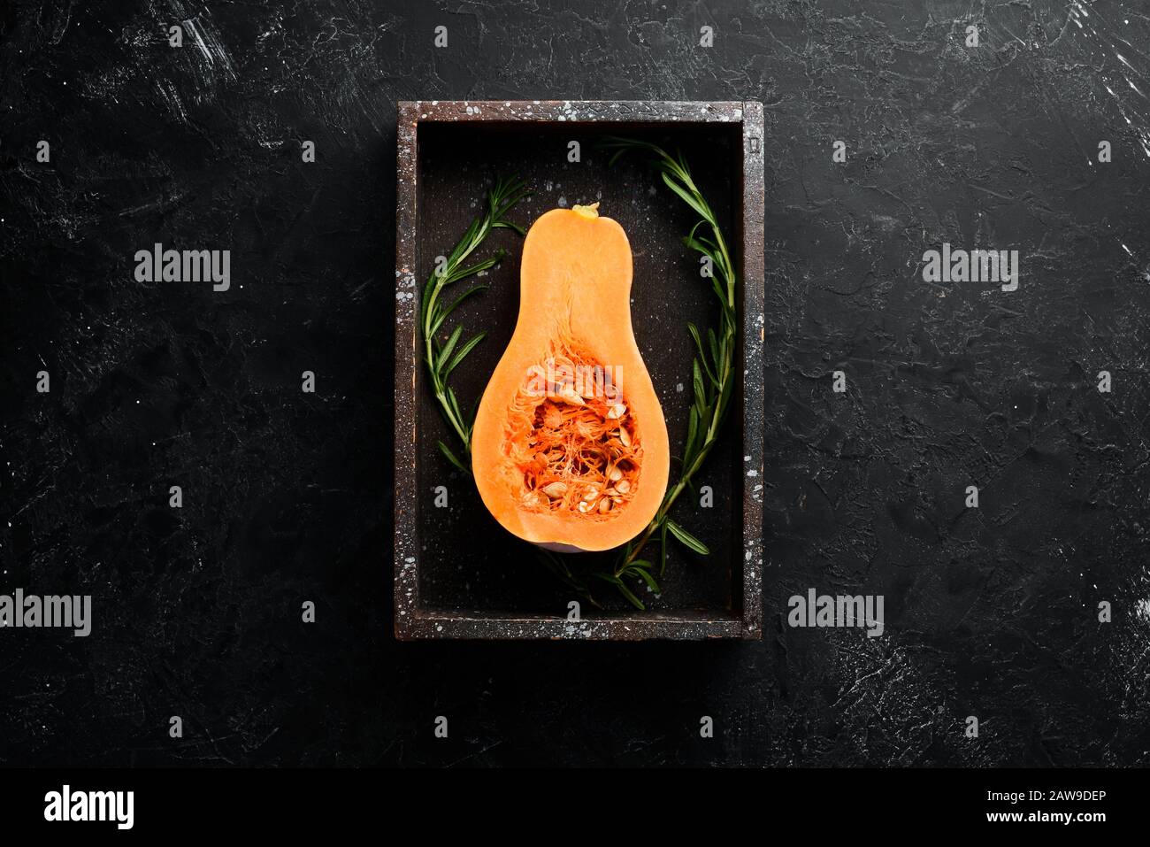 Zucca fresca, verdure autunnali. Su uno sfondo di pietra nera. Vista dall'alto. Spazio libero di copia. Foto Stock