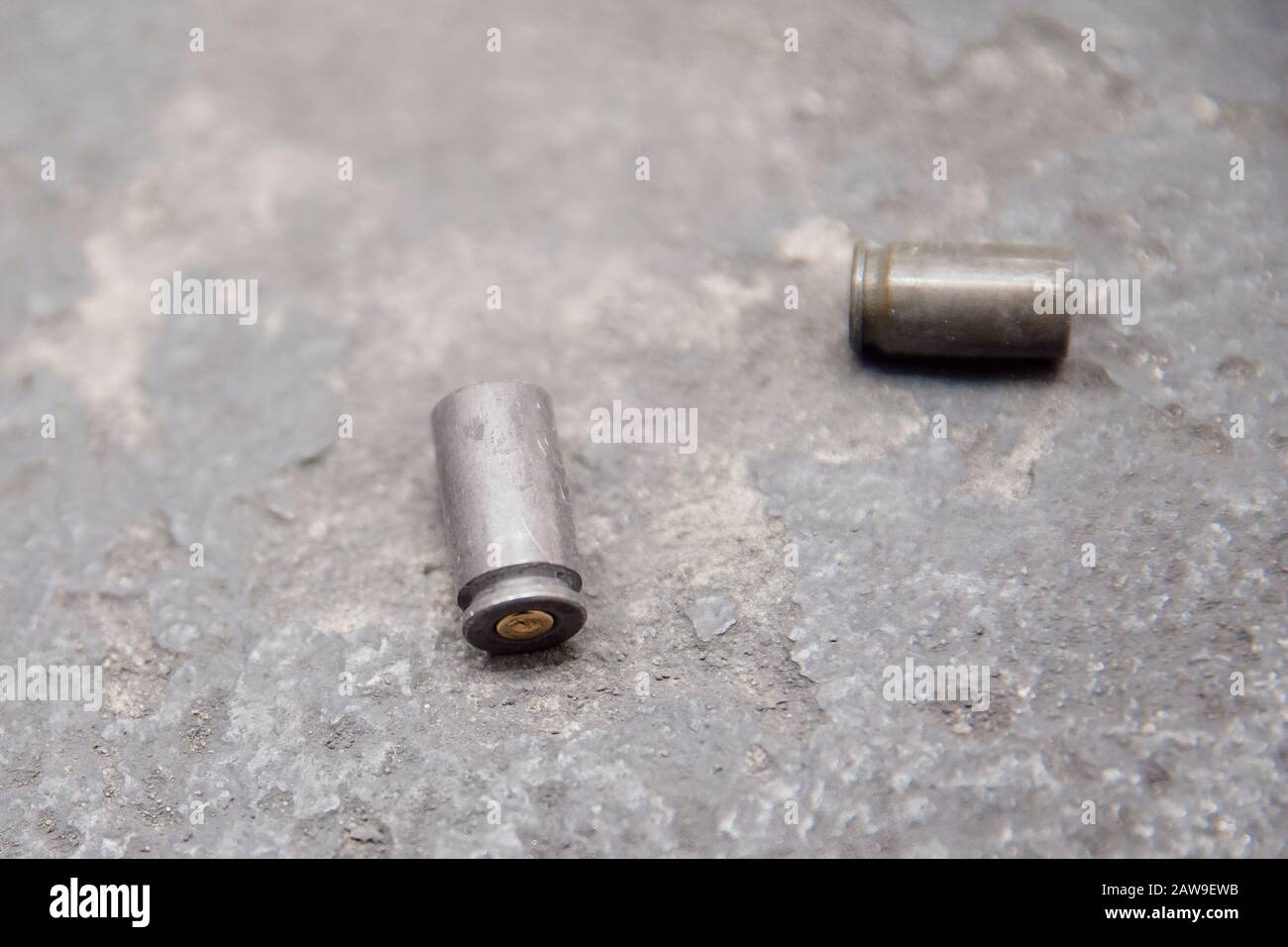 Bullet shell su sfondo grigio in cemento. Campo di tiro. Foto Stock