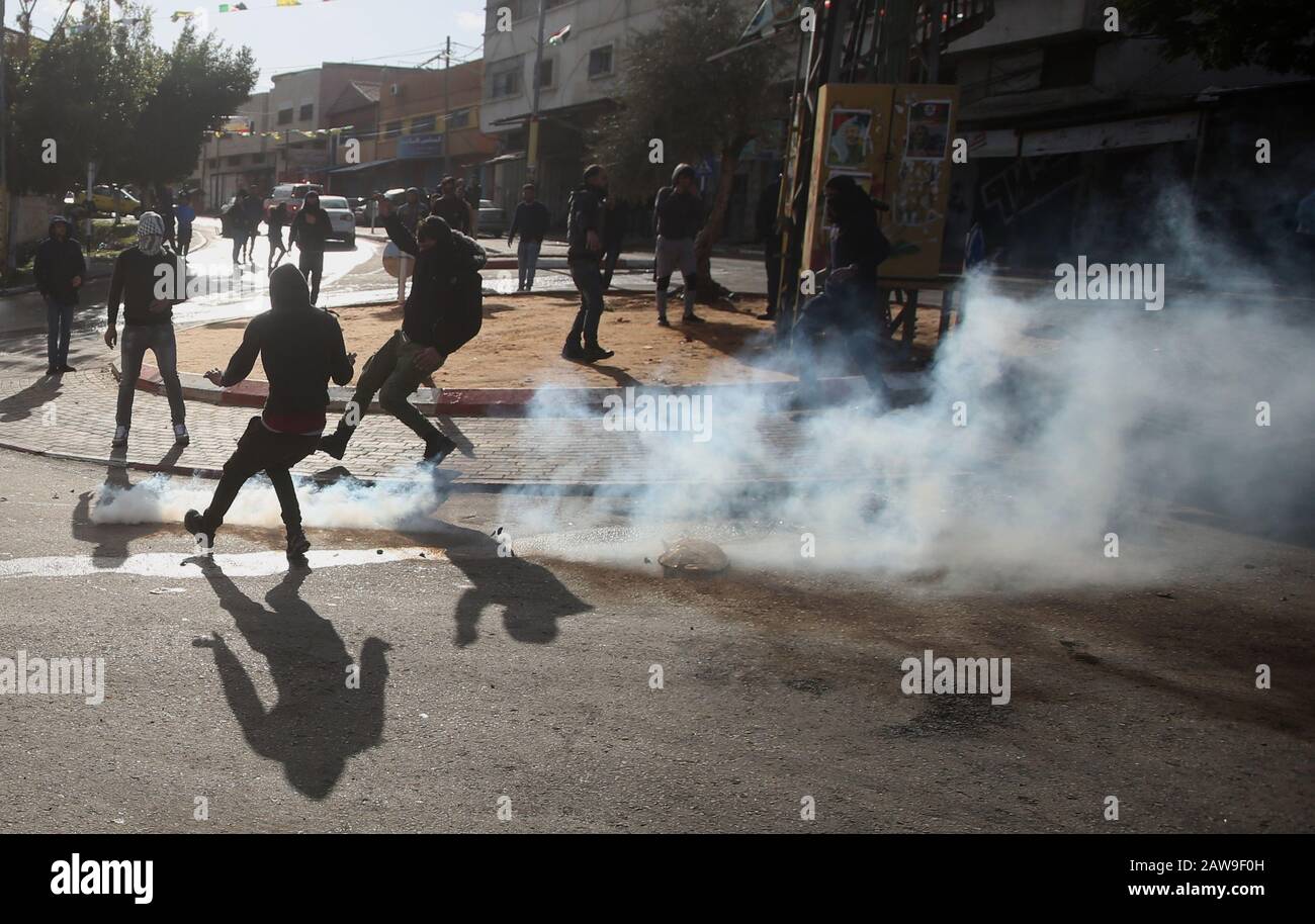 Qalqilya. 7th Feb, 2020. I manifestanti palestinesi corrono per prendere copertura dal canestro di gas lacrimogeno sparato dai soldati israeliani durante gli scontri nella città di Tulkarem, 7 febbraio 2020. Un uomo palestinese è stato ucciso venerdì e decine sono stati feriti durante gli scontri tra dimostranti palestinesi e soldati israeliani in Cisgiordania, ha detto medici e testimoni oculari. Credit: Ayman Nobani/Xinhua/Alamy Live News Foto Stock