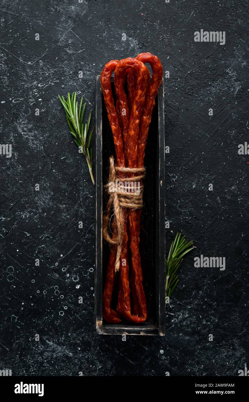 Salsiccia di vitello affumicata secca. Kabanosy. Vista dall'alto. Spazio libero per il testo. Foto Stock