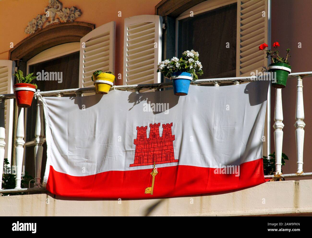 La bandiera di Gibilterra con un castello rosso a tre piani e a tre piani nella sezione bianca che pende dal cancello del castello è una chiave d'oro centrata nella banda rossa Foto Stock