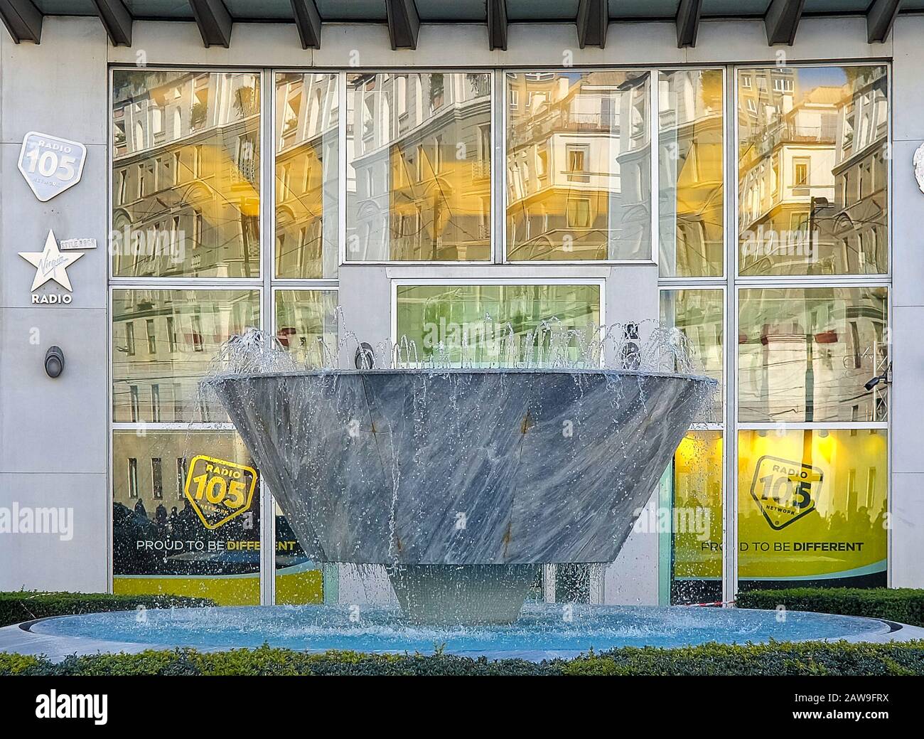 Gio ponti fontana in largo Donegani, Milano, Italia, di fronte al Palazzo  di Montecatini con paesaggio urbano riflesso in finestre Foto stock - Alamy