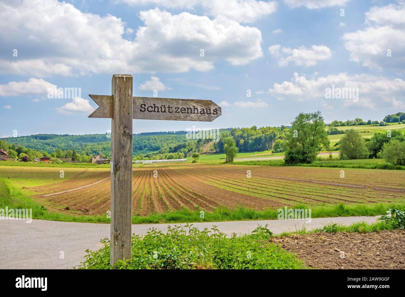 Cartello etichettato con la clubhouse dell'associazione del fucile - in lingua tedesca (Schuetzenhaus) - paesaggio rurale sullo sfondo Foto Stock