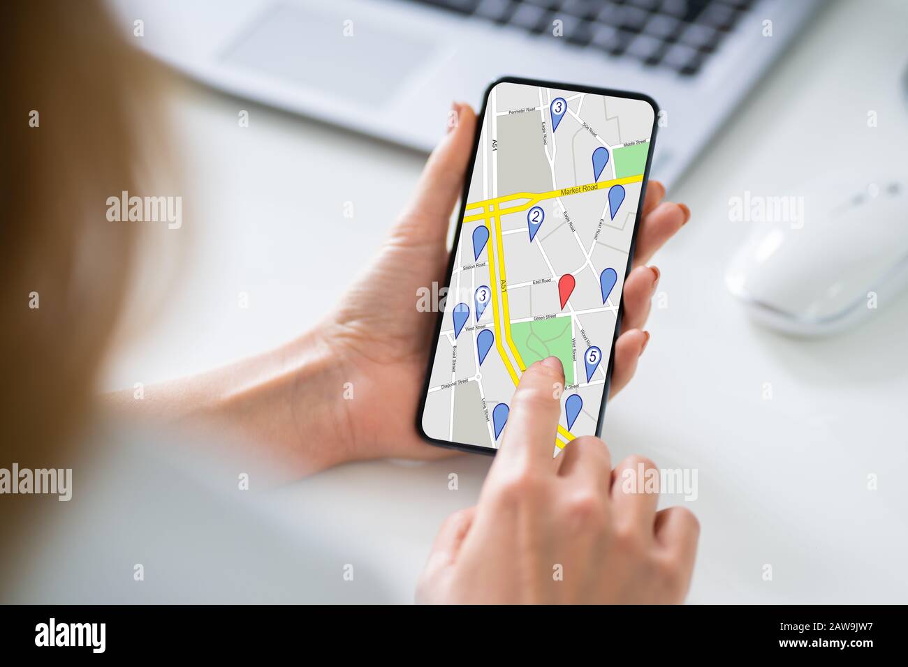 Primo Piano Di Un Telefono Cellulare Woman Holding Con Contrassegno Di Posizione Sulla Mappa Foto Stock