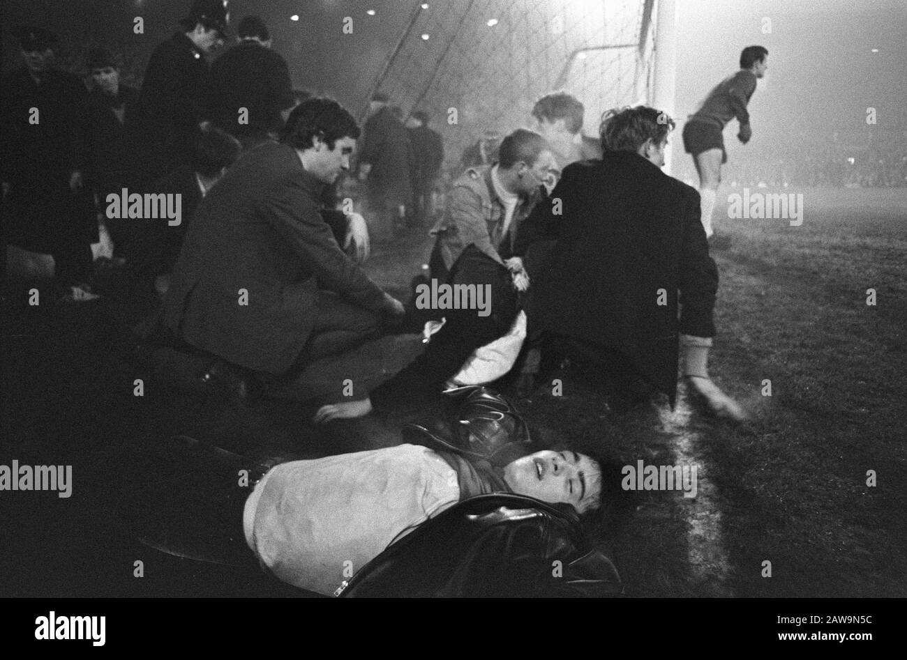 Liverpool contro Ajax 2-2, semi inconscio soccer lungo il campo, portiere Lawrence tutti gli occhi sulla battaglia Data: 14 dicembre 1966 Località: Liverpool Parole Chiave: Sostenitori , custodi, sport, calcio Istituto Nome: AJAX Foto Stock