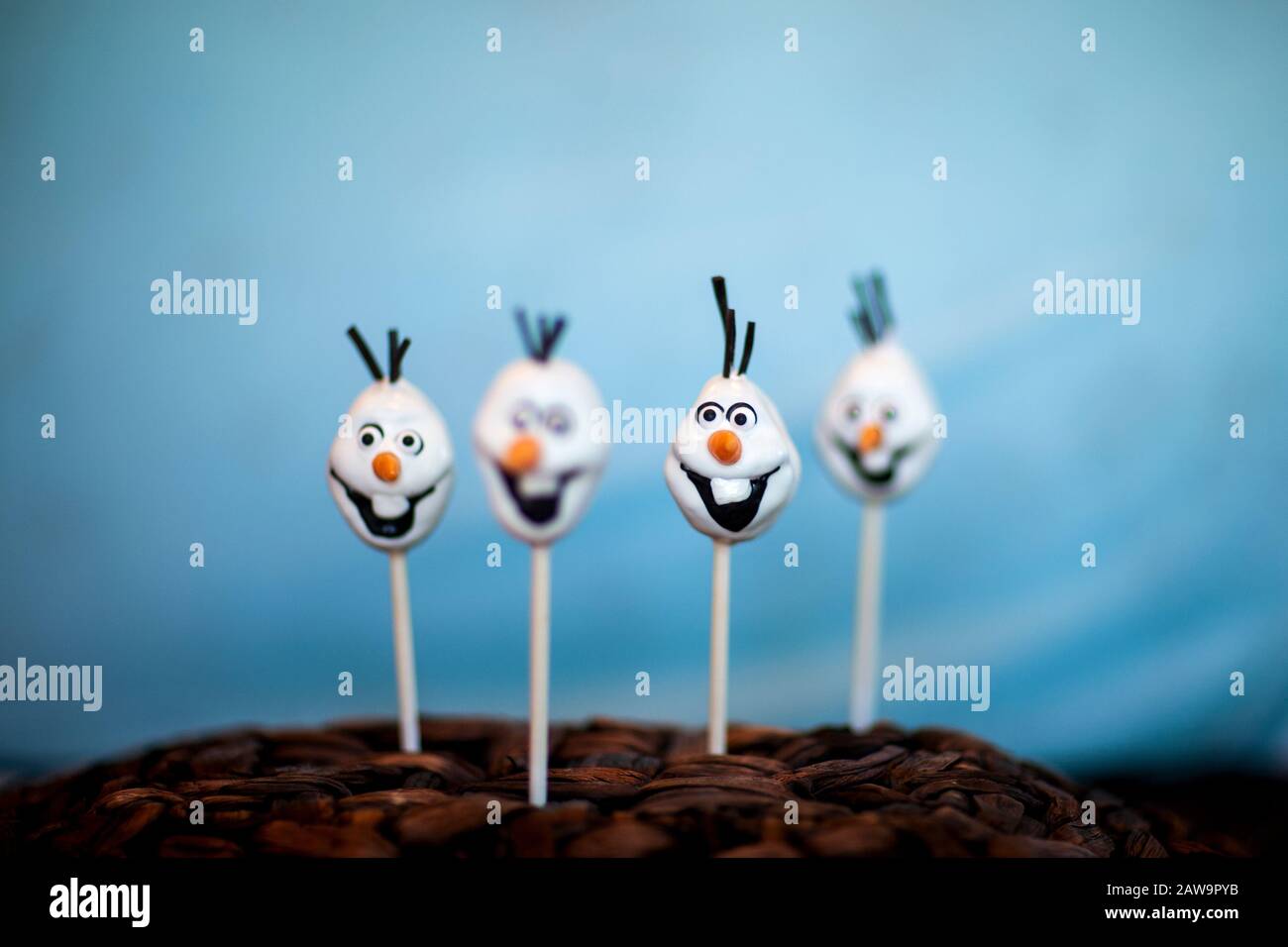 La torta di pupazzo di neve schiocca contro uno sfondo blu Foto Stock